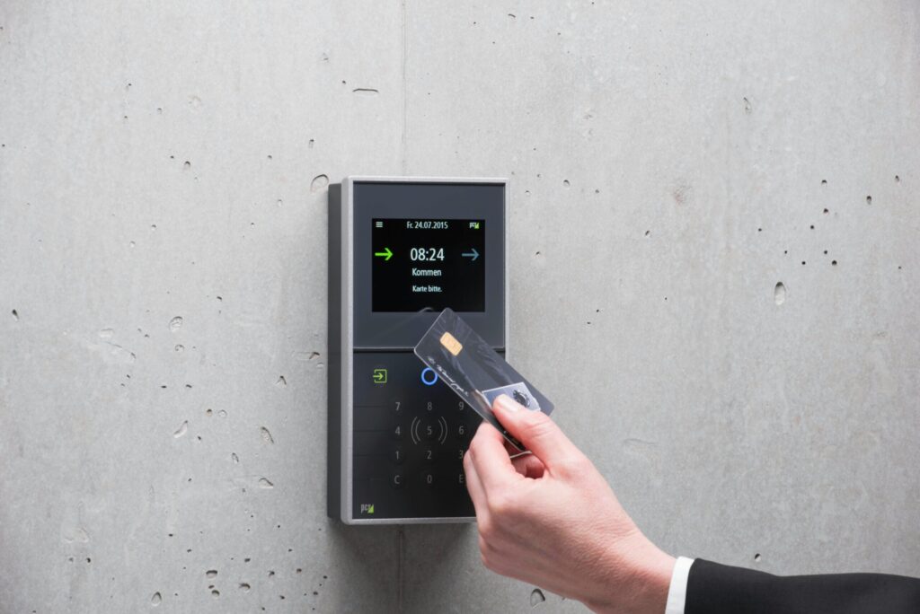A businessman uses a secure card reader access system against a concrete wall, representing the CIA triad principle of confidentiality